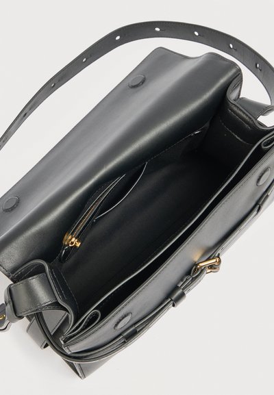 Sort skuldertaske i læder med klap åben, der viser indvendige rum inklusive en lynlåslomme og magnetiske tryklåse.