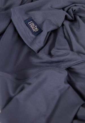 Donkerblauwe, zachte stof met een gladde textuur, met een klein gestikt label waarop "cache coeur" in een elegante lettertype staat.