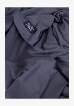 Dark blue, soft fabric with a smooth texture, featuring a small stitched label reading "cache coeur" in an elegant font.