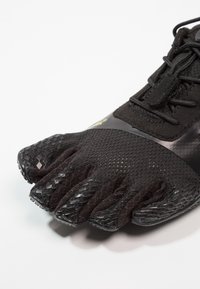 Schwarzer, fünfzehiger Sportschuh mit einem Obermaterial aus Mesh, einer Gummisohle und strukturiertem Grip. Verfügt über Schnürsenkel und ein schlankes Design für Komfort.