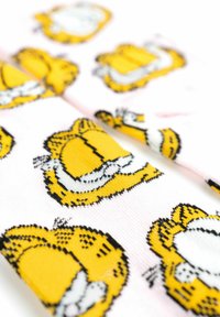 Calzini realizzati in un tessuto morbido, con uno sfondo rosa e stampe ripetute del personaggio di Garfield giallo con dettagli neri.