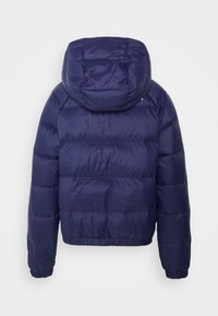 Veste matelassée bleu marine avec capuche, coutures horizontales matelassées, poignets  élastiques et ceinture élastique, vue de dos sur fond blanc.