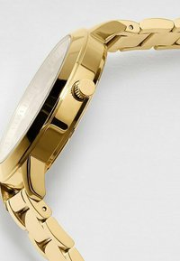 Goldfarbener Uhr mit einem Armband aus Edelstahl, runder Gehäuse und strukturiertem Kranz. Zifferblatt in Weiß mit minimalen Ziffernmarkierungen.