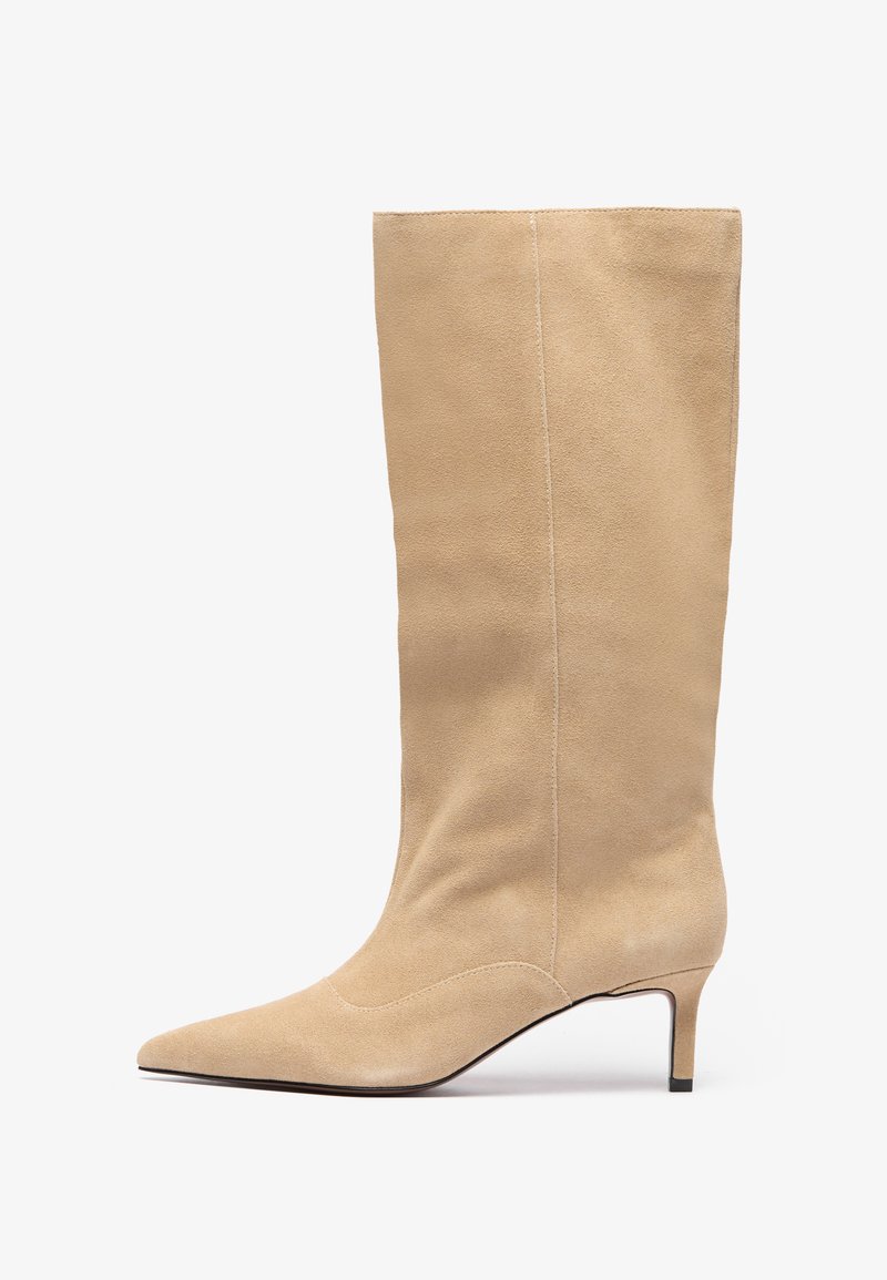 Beige suede knee-high boot with a pointed toe and a slim heel. Features vertical seams along the shaft for added detail.