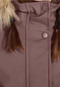 Veste courte violette avec col en fausse fourrure, fermeture éclair et bouton, et couture visible sur un tissu durable. Accentuée par des cheveux brun mi-longs.