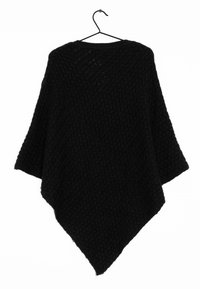 Svart stickad poncho med en texturerad mönster. Har en triangulär form och vida ärmar, hängande från en krok.