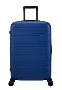 Valise rigide bleue avec des rainures verticales, poignée noire et roues multidirectionnelles. Présente le logo de la marque à l'avant.