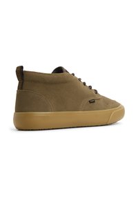 Chaussures en cuir suédé marron, à hauteur de cheville, avec une semelle en caoutchouc beige, dotées d'un système de laçage et d'une languette à rayures à l'arrière.