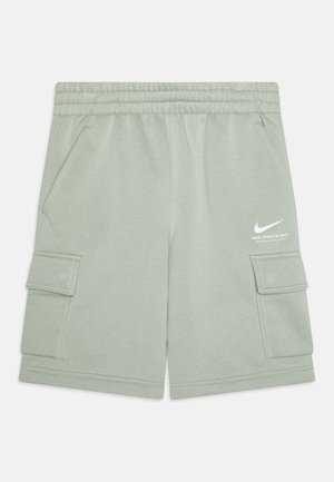 Lysegrønne Nike-shorts med elastisk linning, sidelommer, cargolommer og hvid Nike-logo på højre lår.
