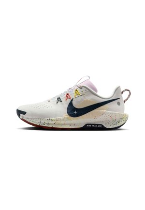 White Nike trail running shoe with multicolor lace eyelets, black swoosh, speckled midsole, and pull tab at heel on white background.