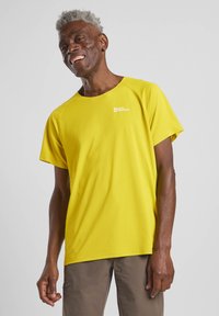 T-shirt giallo a maniche corte con tessuto strutturato, dotato di un piccolo logo sul petto e una vestibilità rilassata. Adatto per l'uso all'aperto.