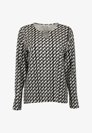 T-shirt à manches longues en noir et blanc, présentant un motif géométrique avec un col rond et un détail de découpes circulaires à l'avant.