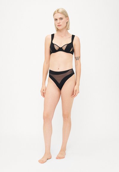 Zwart lingerie set bestaande uit een bralette met gaasdetails en brede banden, gecombineerd met hoogtaille broekjes met gaasaccenten. Gladde textuur.