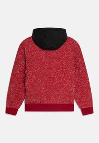 Rode gewatteerde jas met een gestructureerd, gemarmerd patroon en zwarte capuchon, voorzien van elastische manchetten en een elastische tailleband voor een beveiligde pasvorm.