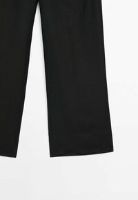 Pantalon noir à jambes larges, visible de la mi-cuisse à la cheville sur fond blanc, avec des ourlets droits et une texture de tissu lisse.