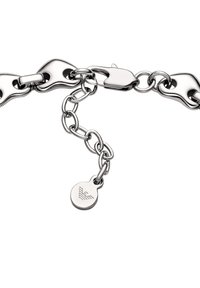 Pulsera de metal plateado con eslabones redondeados, cierre de langosta y una pequeña etiqueta con un diseño en relieve. Textura suave y acabado pulido.