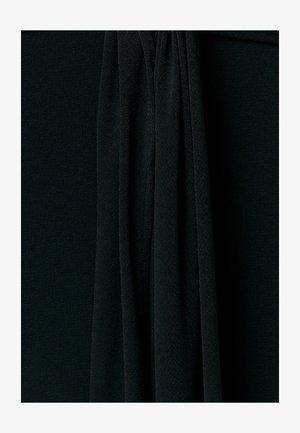 Crni teksturirani materijal s okomitim naborima koji stvaraju mekane sjene i dubinu u užem prikazu.