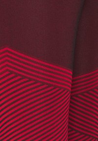 Textile featuring a deep red and dark maroon color scheme with vertical ribbed texture and diagonal striped pattern in bright red.