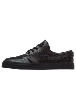 Sort læder slip-on sneaker med snørebånd, tekstureret overdel, flad sål og subtil Nike-swoosh-logo på siden, set fra ydersiden.