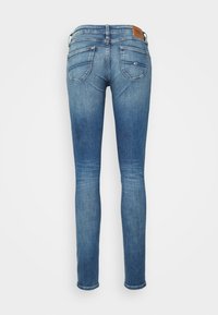 Tajta jeans i mellanmörk denim med en urtvättad finish, med bakfickor och en läderlogotyp på linningen.
