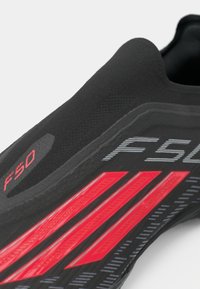 Μαύρο αθλητικό παπούτσι με κομψό σχέδιο, που διαθέτει κόκκινες και γκρίζες λεπτομέρειες, υφή επιφανειών και εξέχον λογότυπο "F50" στο πλάι.