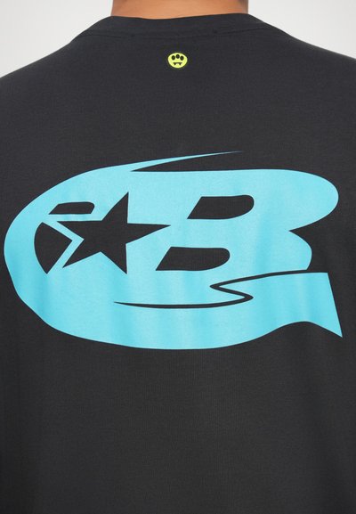 Schwarzes T-Shirt mit einem großen türkisen Grafikdesign, das einen Stern und den Buchstaben "B" zeigt. Enthält ein kleines gelbes Logo am Halsausschnitt.