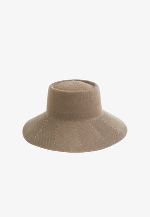 Platus kraštų smėlio spalvos megztas saulės skrybėlis su aukšta karūna ir tekstūriniu raštu, atvaizduotas baltame fone.