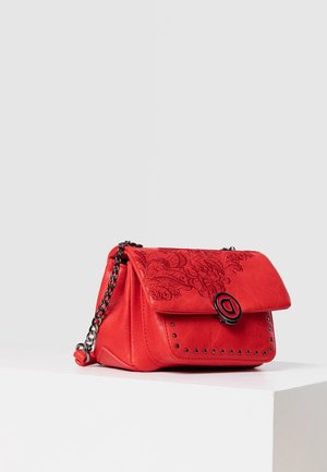 Rode leren handtas met geperst bloemenpatroon op de klep, zwarte ronde sluiting, zwarte studs op het voorvak en een zwarte metalen kettingriem.