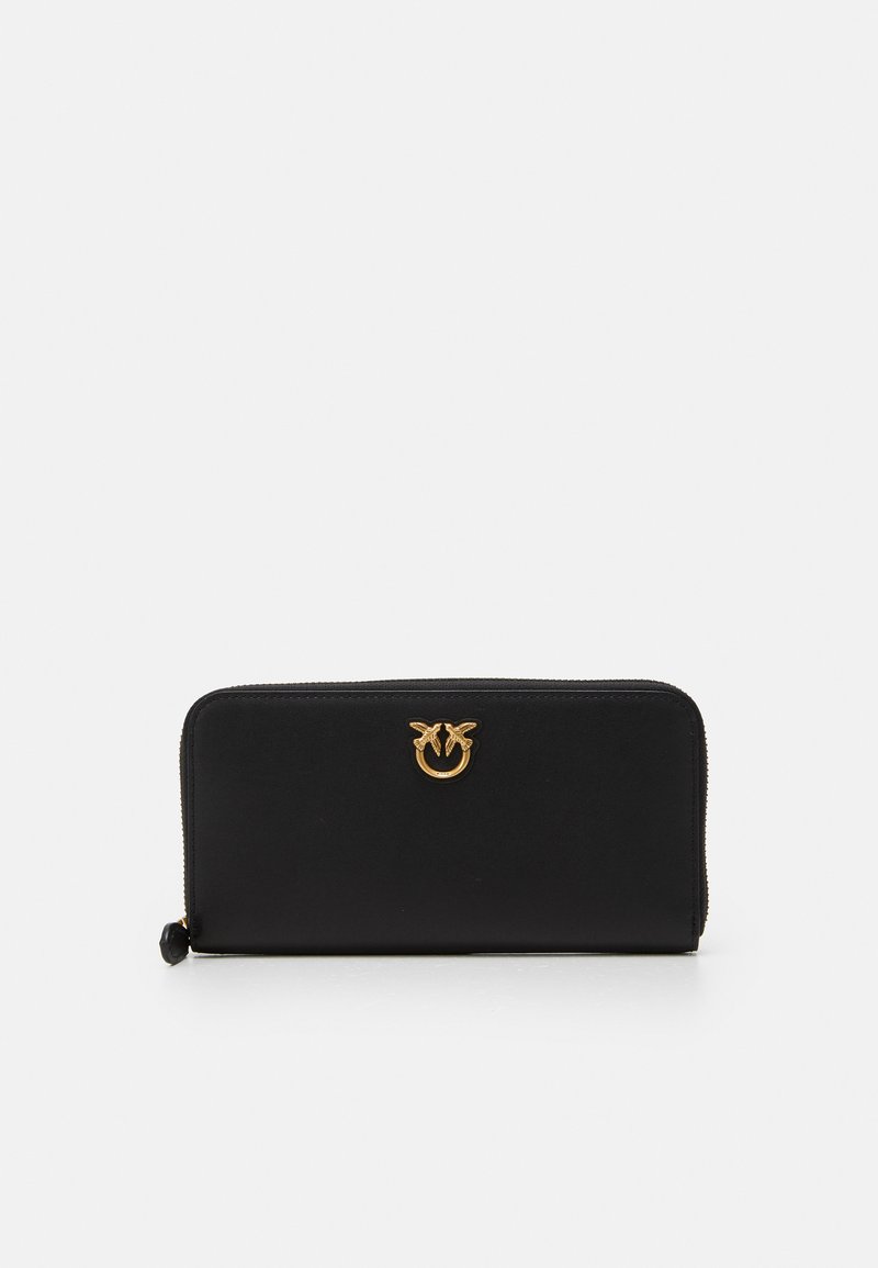 Portafoglio nero con zip realizzato in pelle liscia, caratterizzato da un accento con logo dorato sulla parte anteriore e un design minimalista.