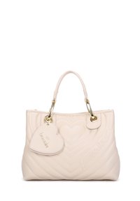 Borsa a tracolla beige trapuntata con motivi a cuore, hardware dorato, doppi manici superiori e un'etichetta a forma di cuore removibile con testo embossato.