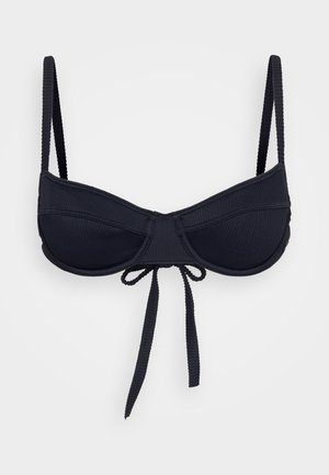 Zwarte geribbelde bikini-top met onderdraad, verstelbare schouderbanden en een strikdetail in het midden voor een aangepaste pasvorm. Heeft een gladde textuur.