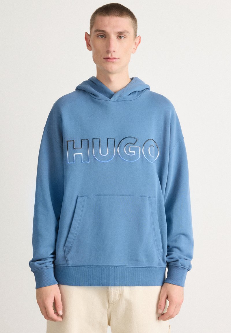 Felpa blu con tasca kangaroo frontale, caratterizzata dalla scritta "HUGO" in grassetto e con lettering a contrasto. Realizzata in morbido tessuto testurizzato.
