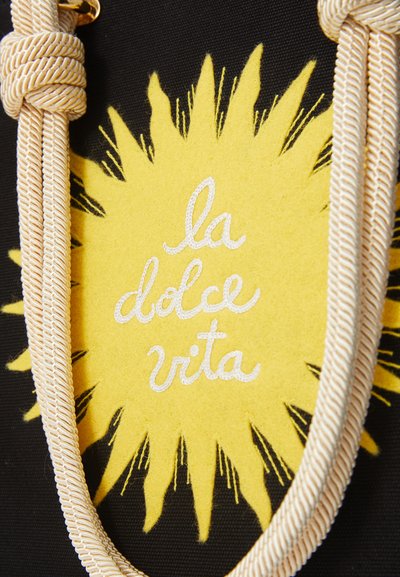 Black fabric with yellow sunburst design, featuring the phrase "la dolce vita" in white embroidery and a textured beige braided strap.