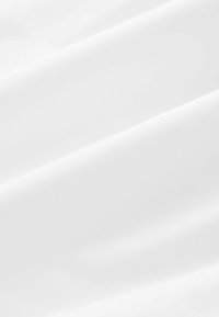 Tissu blanc avec une texture lisse, un léger éclat et des plis doux, mettant en valeur un design simple et uniforme sans motifs ni accents.
