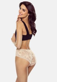Schwarzer Bh mit breiten Trägern, kombiniert mit hellbeige Unterhosen im Boyshort-Stil, die ein florales Muster und eine halbtransparente Textur aufweisen, wobei die Rückansicht gezeigt wird.