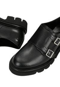 Schwarze Ledermonks mit dicken, robusten Sohlen und silbernen Doppel-Schnallen, aus schrägen oberen und seitlichen Blickwinkeln gezeigt.