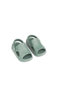 Vihreät kumiset sandaalit, joissa on avoimet varpaat, sivuleikkaukset ja takahihnat, teksturoitu pohjallinen ja sileä ulkopinta.