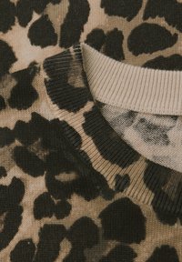 Leopardenmuster-Pullover mit beigem Hintergrund und schwarzen Flecken, geripptem Ausschnitt und weicher Strickstruktur.