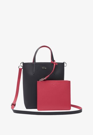 Borsa tote in pelle nera con accenti rossi, dotata di manici doppi, una tracolla rimovibile e una piccola pochette rossa coordinata.