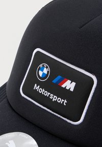 Μαύρο καπέλο με ορθογώνιο ένθετο που έχει το λογότυπο BMW, ρίγες M σε μπλε, κόκκινο και λευκό, και τη λέξη "Motorsport" κεντημένη με άσπρα γράμματα.
