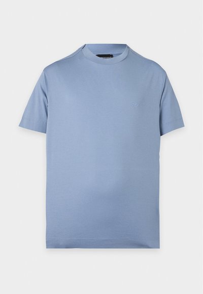 Απλό γαλάζιο T-shirt με κοντά μανίκια και στρογγυλή λαιμόκοψη, με μικρό διακριτικό λογότυπο στο αριστερό μέρος του στήθους σε λευκό φόντο.