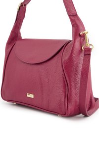 Burgundy leather handbag with a textured surface, rounded flap, detachable strap, and gold hardware accent. Compact rectangular shape.