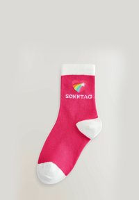 Calcetín de algodón rosa con puño y punta blanca acanalados. Presenta un logo de corazón con un arcoíris y una estrella, y la palabra "SONNTAG" en texto blanco.