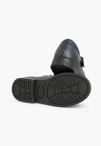 Zapato de cuero con suela de goma negra, con punta redondeada, parte superior lisa en tono navy y sin hardware o acentos visibles.