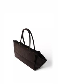 Sac cabas en daim marron foncé avec deux longues anses et une poche avant, présenté légèrement en angle sur fond blanc.