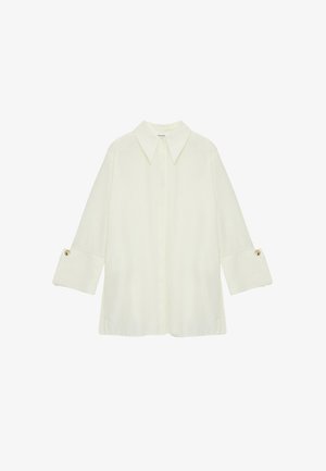 Svijetlo krema košulja s ovratnikom i dugim rukavima, s dugmadima na manžetama. Izrađena od glatke tkanine s opuštenim krojem.
