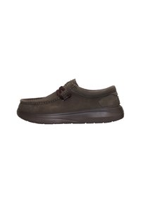 Zapato de ante marrón tipo slip-on con punta redondeada, costuras en contraste y cordones oscuros; cuenta con una suela de goma gruesa y texturizada para mayor comodidad.