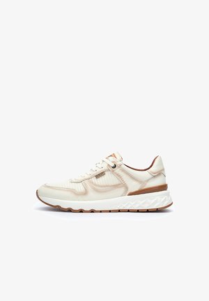 Zapatilla de color crema con cuero texturizado, una suela blanca gruesa y acentos marrones. Presenta cordones redondos y paneles laterales acolchados.