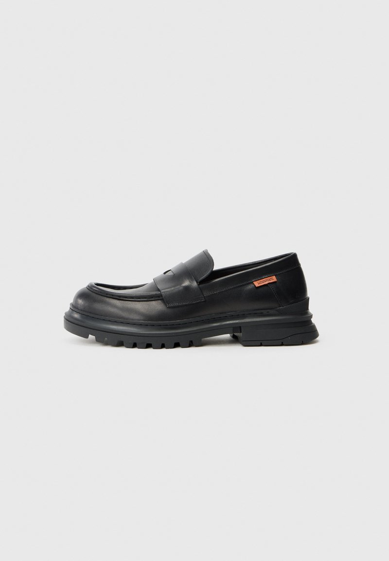 Must have nahk Loafers ümarate varvastega, madala kontsaga ja paksu, tekstuuriga kummitald. Omab õmblusaksenti ja väikest logo küljes.