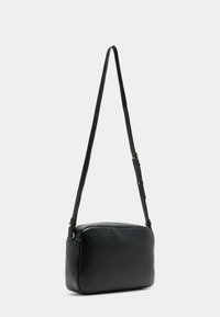 Sac à bandoulière noir en cuir au format rectangulaire, surface texturée, avec une sangle slim ajustable et des accents en métal doré.